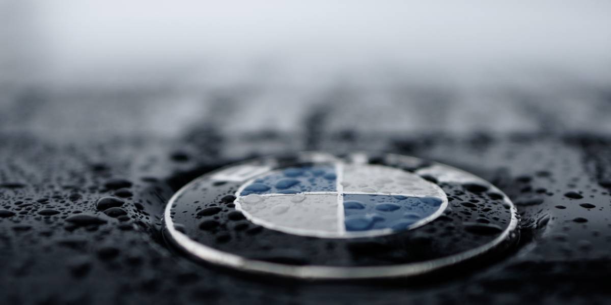 BMW-Logo auf schwarzem Grund mit Regentropfen. BMW Ankauf durch autolos.de