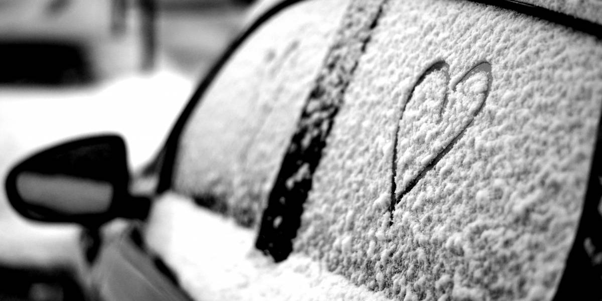 Linke Autoseite, schneebedeckt schwarz-weiß mit in den Schnee gemalten Herzen an den Seitenscheiben. Mein Auto verkaufen an autolos.de